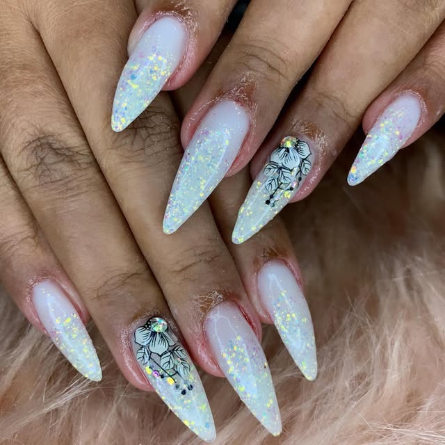 Unhas stiletto brancas com glitter e flor desenhada
